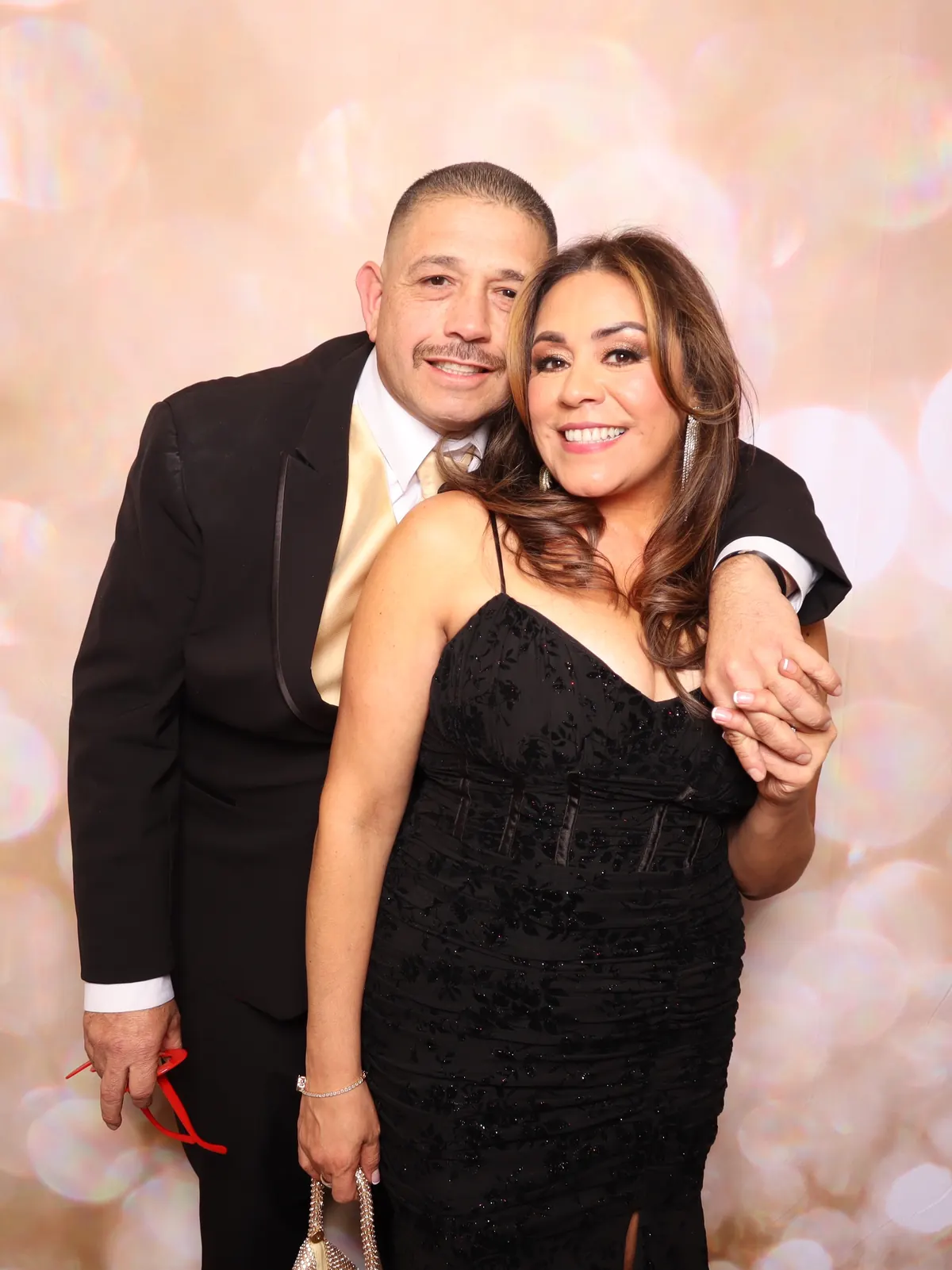 A couple photographed against the blush backdrop