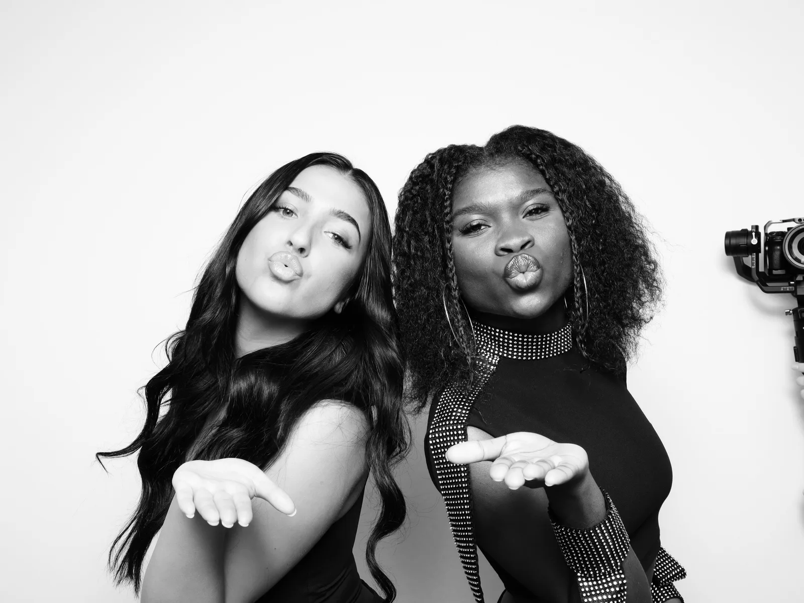 Two guests blowing kisses in the booth