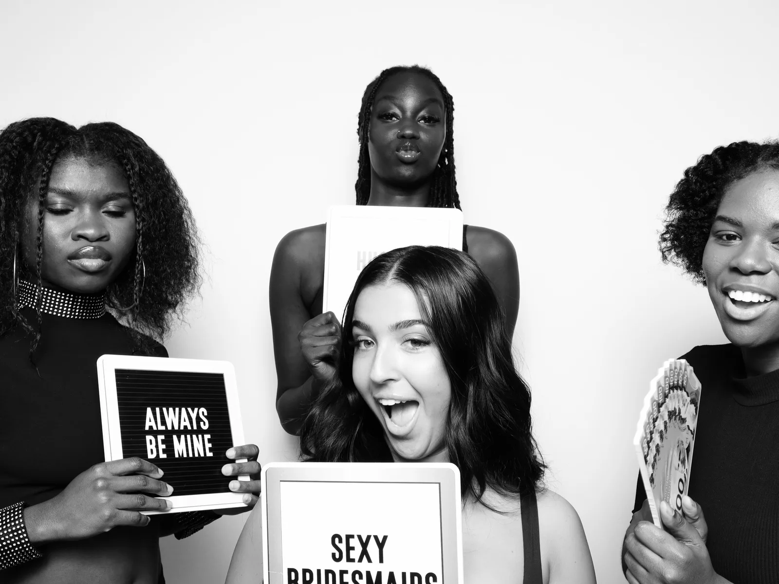 Bridesmaids posing with props in the booth